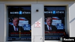 在以色列的特拉维夫,有人坐在电子屏幕前,屏幕上有川普当选的画面(2016年11月9日)