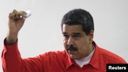 委内瑞拉总统马杜罗展示他在周日制宪大会选举中投下的选票。(2017年7月30日)