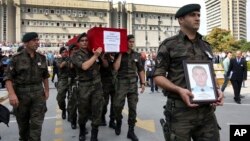 FILE - Turkish police officers carry the coffin of Turkish police special operations officer Sahin Polat Aydin, one of the four officers killed in a landmine attack attributed to PKK militants in Silopi, southeastern Turkey, during a ceremony in Ankara, Aug. 11, 2015.