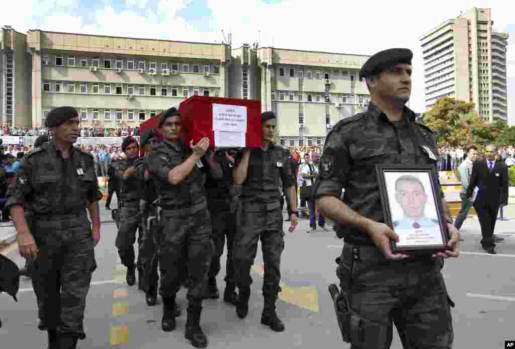Turkish police officers carry the coffin of Turkish police special operations officer Sahin Polat Aydin, one of the four officers killed Monday in a landmine attack attributed to militants of the Kurdistan Workers' Party, or PKK, in Silopi, southeastern Turkey, during a ceremony in Ankara, Aug. 11, 2015.