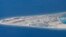 FILE - Chinese structures and an airstrip on the man-made Subi Reef at the Spratly group of islands in the South China Sea are seen from a Philippine Air Force C-130 transport plane of the Philippine Air Force, April 21, 2017.