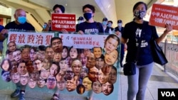 香港社民连主席陈宝莹(右起)与外务副主席周嘉发、成员余炜彬及前东区区议员曾健成,在十一中国国庆日游行,要求全中国实行普选、释放所有政治犯 (美国之音/汤惠芸)