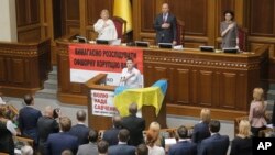 Ukrainian military pilot Nadiya Savchenko, center, and lawmakers sing the national anthem during a parliament session in Kyiv, Ukraine, May 31, 2016. Savchenko appeared for her first session at the Ukrainian parliament after being released last week from