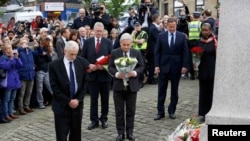英国首相卡梅伦(右二)与工党党魁科尔宾(左)与其他英国议员在考克斯议员被害地点附近献花。(2016年6月17日)