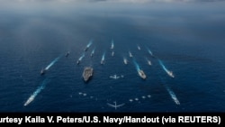 美国海军资料照片:日本海上自卫队“日向号”直升机驱逐舰与美国尼米兹级核动力航母“罗纳德·里根号”和美日其他16艘战舰在菲律宾海进行演习。(2018年11月8日)