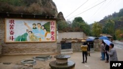 2016年10月22日,在中国陕西省梁家河,中国国家主席习近平青年时期生活过的窑洞外面有一幅描绘青年习近平指引方向的壁画。