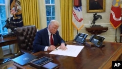 资料照:美国总统特朗普在白宫椭圆形办公室签署行政令。(2025年1月30日)
