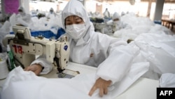 在浙江温州一家工厂,工人们在制作防护服。(2020年2月28日)