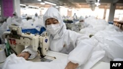 在温州一家工厂，工人们正在缝制防护服。（2020年2月28日）