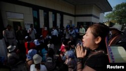 安保人员逮捕数名向大使馆提交请愿书的抗议者后,另一名抗议者在美国大使馆前哭泣。(缅甸,金边,1月21日,2014)