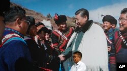 四川成都一名拿着雨伞的男子走过一家酒店张贴的中国领导人习近平会见少数民族人士的宣传画。(2020年9月9日)