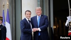 French President Emmanuel Macron greets U.S. President Donald Trump
