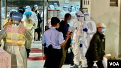 大批警员和卫生署人员12月10日到香港九龙湾丽晶花园协助居民撤离到新冠疫情隔离营。(美国之音汤惠芸拍摄)