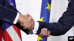 美国总统特朗普和法国总统马克龙在七国集团峰会的新闻发布会上握手(2019年8月26日)。
