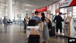တရုတ်နိုင်ငံ Beijing မြို့ရဲ့ အပြည်ပြည်ဆိုင်ရာ လေဆိပ်မှာ ခရီးသွားတချို့ လေယာဉ်ပျံလက်မှတ်ကို စစ်ဆေးနေကြတဲ့ မြင်ကွင်း။ (ဇွန် ၁၇၊ ၂၀၂၀)