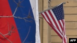 A Russian national tricolor flag flies next to a US national flag sitting on the US embassy building in Moscow on March 13, 2025.