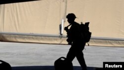 资料照片:一名美国陆军军人在巴格达以北的塔吉基地参加将基地控制权从联军移交给伊拉克安全部队的仪式。(2020年8月23日)