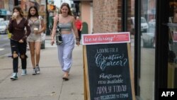 2021 年 8 月 20 日一群年轻人走过纽约市一家商店张贴的“我们在招聘!” 标志。(照片来源:法新社)