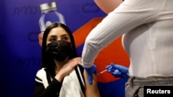 资料照片:以色列赫兹利亚的一名妇女在接种新冠疫苗。