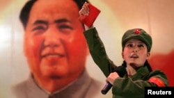 资料照:一名红卫兵手举毛主席语录在毛泽东画像前跳忠字舞