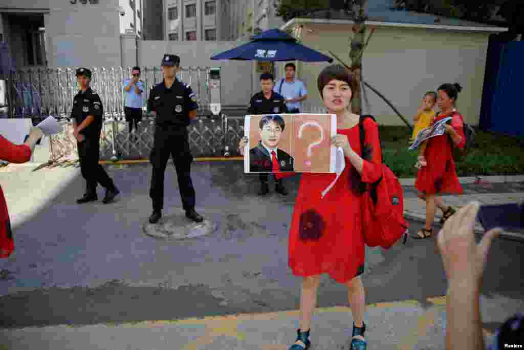 2017年7月7日,在709镇压中被捕的维权律师王全璋的妻子李文足和别人一道在中国最高人民检察院前面抗议,她手持王全璋像和问号。