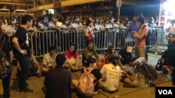 从10点前,在中联办外德辅道西上的警察由手持约一米七高的长盾牌的防暴警察替换到最前排,做好准备清场的准备。示威者则用铁马和雨伞筑成防线,应对警方的清场。另外,在西边街,也有一些示威者与警方对峙,但场面没有在德辅道上紧张。目前,现场仍有近千人。