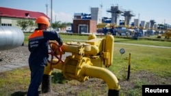 一名工人在乌克兰的一处地下天然气储藏设施附近转动阀门。(2014年5月21日资料照)