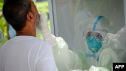 ရန်ကုန်ရှိ ကွာရန်တင်းစင်တာမှ နှာခေါင်း၊ အာခေါင် တို့ဖတ်နမူနာ ယူနေစဉ်