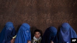 资料照片:2021年11月20日,在阿富汗喀布尔,世界粮食计划署组织的一个现金分发点,阿富汗妇女等待领取现金。一位高级官员于2023年7月28日星期五表示,由于“严重的资金危机”,联合国被迫削减对许多国家数百万人的粮食、现金支付和援助,由于严重饥饿达到创纪录的水平,联合国的捐款暴跌了约一半。