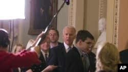 美国副总统拜登(中)同参议院多数党领袖里德和多数党督导员德宾2012年12月31日就避免财政悬崖问题前往国会山举行民主党党团会议。