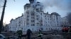 Petugas sedang berupaya memadamkan api di sebuah gedung setelah serangan Rusia di Kyiv, Ukraina, Kamis, 21 Maret 2024. (AP Photo/Vadim Ghirda)