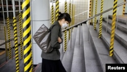 一名戴着口罩的韩国女子走上首尔地铁的台阶。(2020年2月20日)