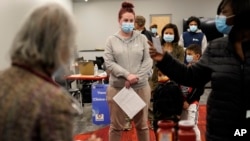 资料照片:人们在马萨诸塞州的伍切斯特的一处移动疫苗接种站点排队等待接种辉瑞新冠疫苗加强针。 (2021年12月2日)