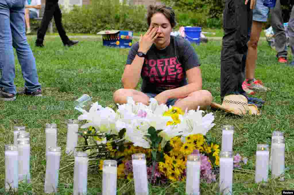 A local resident of Charlottesville wipes tears from her eyes at a vigil where 20 candles were burned for the 19 people injured and one killed when a car plowed into a crowd of counter protesters at the "Unite the Right" rally organized by white nationalists in Charlottesville, Virginia, Aug. 12, 2017.