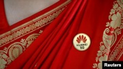 印度一名妇女2019年10月在一次移动电信展销会上佩戴华为5G胸章(路透社)
