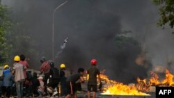 ှမြန်မာဆန္ဒပြသူတွေက ဓာတ်ဆီဗုံးကို သုံးပြီး ရဲဖြိုခွဲမှုကို အံတုစဉ် (ဓာတ်ပုံ- AFP)