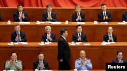 资料照片:2018年5月4日北京人民大会堂举行纪念共产主义创始人马克思诞辰200周年活动,中国国家主席习近平发表演讲后走回座位上。前排就坐者左起:张又侠、杨洁篪、许其亮、丁薛祥。