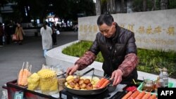 3月4日,一名街头小吃摊贩在中国西南部重庆市中心的街道上工作。