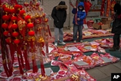 北京居民在人行道的地摊上购买春节年货。(2025年1月26日)