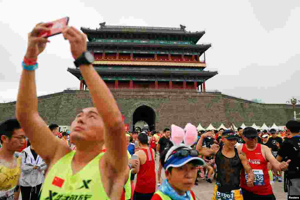 2018年9月16日在北京天安门广场南端,前门城楼下,人们准备参加马拉松赛,有人用手机自拍。