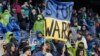 Антивоєнний постер на спортивних трибунах, Сіетл, США. AP Photo/Ted S. Warren