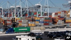 资料照片:2015年2月23日,一辆半拖集装箱离开洛杉矶港。(美联社照片)