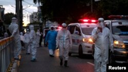 တာဝန်ထမ်းဆောင်နေကြသော PPE ဝတ်စုံနှင့် ကျန်းမာရေးဝန်ထမ်းများကို ရန်ကုန်မြို့ရှိ လမ်းတခုတွင်တွေ့ရ။ (စက်တင်ဘာ ၂၇၊ ၂၀၂၀)