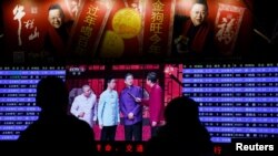 资料照:人们在北京西站观看央视的春晚节目。(2018年1月15日)