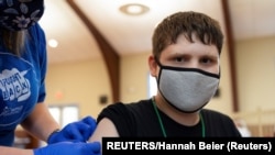 USA, Pennsylvania, Thomas Macconnell, 16, who is on the autism spectrum, is given a band-aid after receiving a coronavirus disease (COVID-19) vaccine