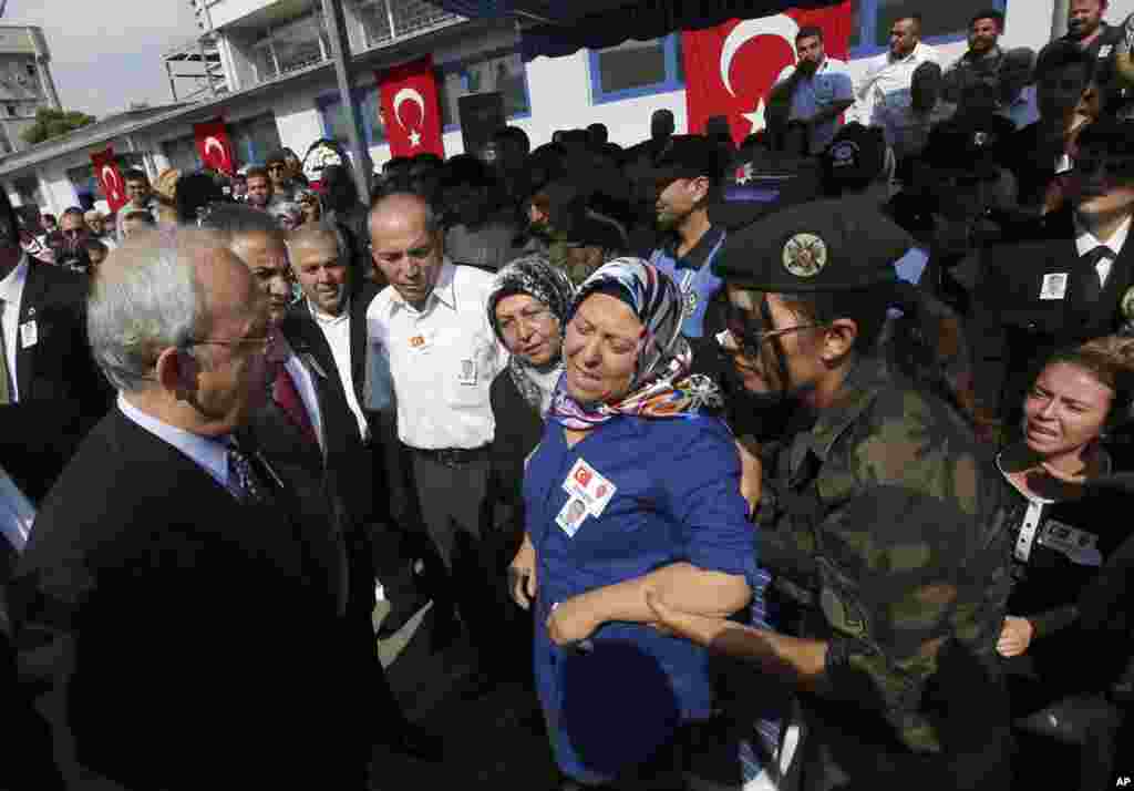 The leader of Turkey's main opposition Republican People's Party (CHP) Kemal Kilicdaroglu (left) pays his condolences to Hulya Aydin, the mother of Turkish police special operations officer Sahin Polat Aydin, one of the four officers killed Monday in a landmine attack,  Ankara, Turkey, Aug. 11, 2015.