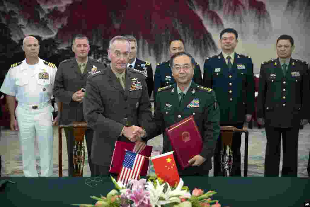 美军参谋长联席会议主席邓福德与中国人民解放军总参谋长房峰辉在北京八一大楼签署协议后握手(2017年8月15日) 。房峰辉作为军令方面的高官,和外国人接触的机会远远多于军政方面的高官张阳。