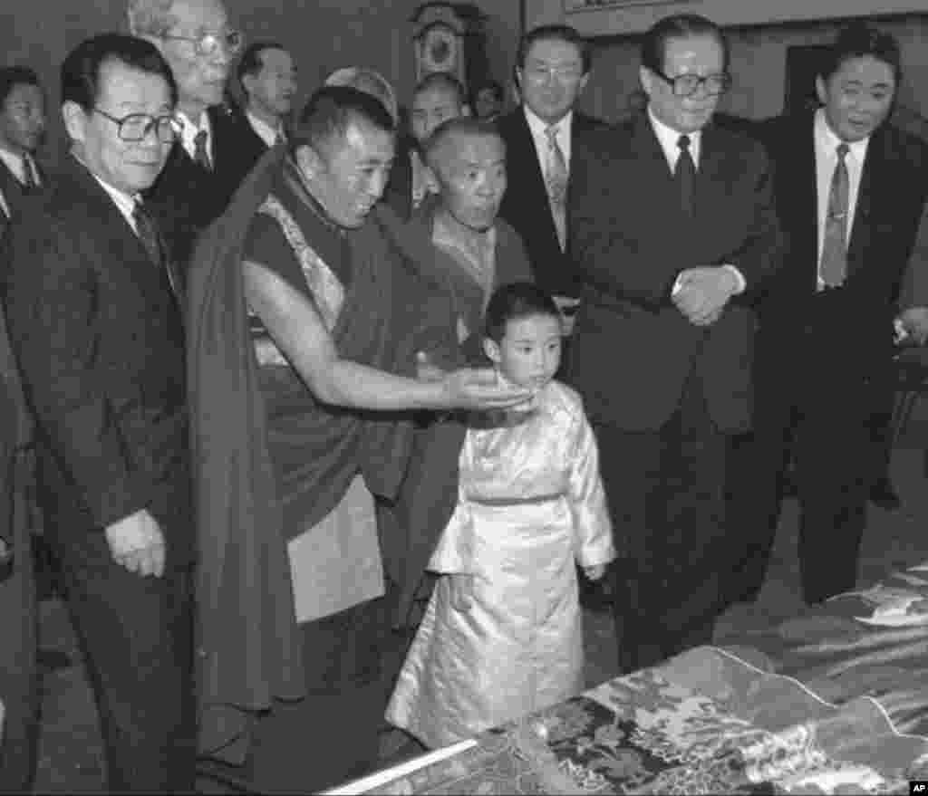 1996年1月12日,中国官方选择的六岁的11世班禅喇嘛向中国主席江泽民呈现给他的礼品。中国政协主席李瑞环在场。