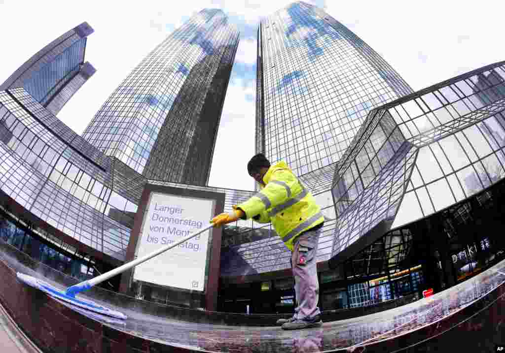 在德国法兰克福的德意志银行大楼前,清洁工人在工作。华尔街日报引用一些银行家的话说,当海航集团在海外大肆收购的时候,各路投行也为赢得海航集团的生意展开激烈竞争。