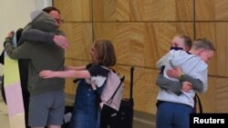 来自新西兰的旅客2021年4月19日在抵达悉尼国际机场时与亲人拥抱团聚（路透社）